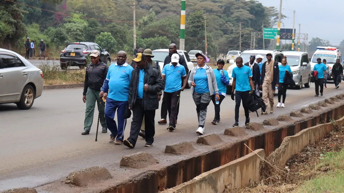 Finishing Well Foundation walkers in blue shirts on a Nairobi road during the Walk for Fitness