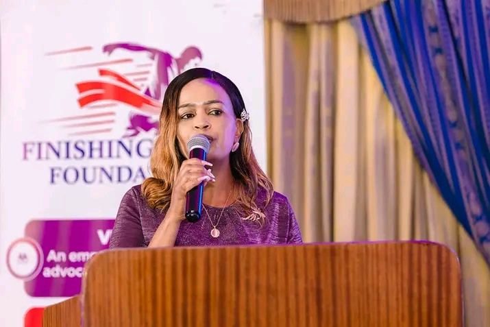 Fraciah Njoki addressing a gathering at the Finishing Well Foundation podium